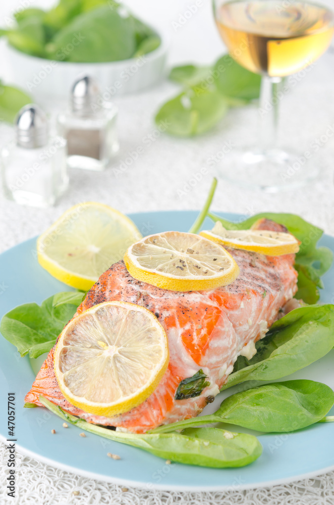 Baked salmon fillet with lemon and spinach and a glass of white Baked salmon fillet with lemon and spinach and a glass of white