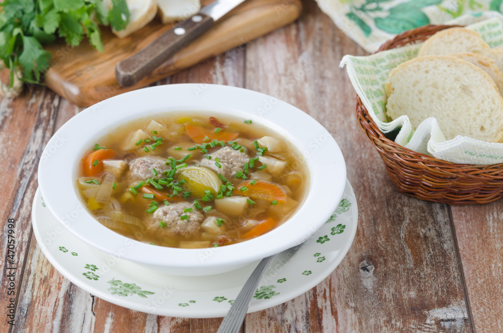 Plate of vegetable soup with meatballs on the wooden table Plate of vegetable soup with meatballs on the wooden table