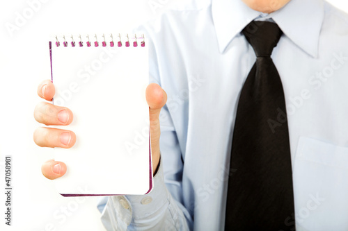 Young businessman holding a notebook or a card in the hand isola