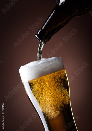 beer glass and bottle on a brown