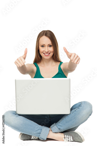 Woman with laptop showing thumbs up © pikselstock