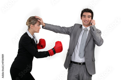 Businesswoman trying to box a man on a phone