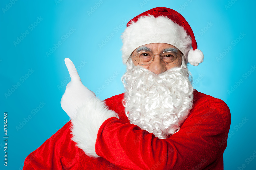Father Christmas pointing away, copy space area Father Christmas pointing away, copy space area