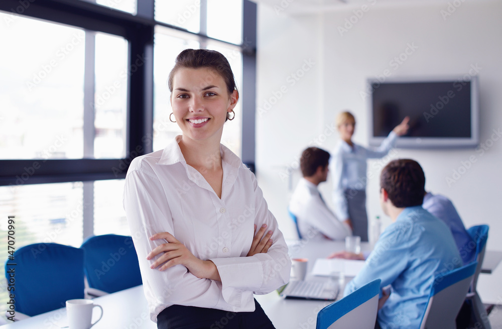 business woman with her staff in background at office