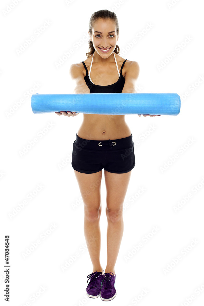 Woman holding a blue mat in her outstretched arms Woman holding a blue mat in her outstretched arms