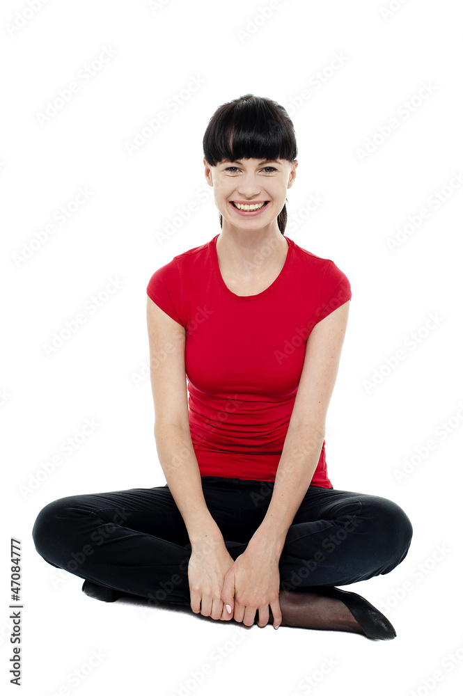 Relaxed smiling trendy woman sitting in studio floor Relaxed smiling trendy woman sitting in studio floor