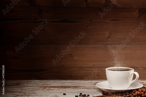 white cup of coffee over wooden background