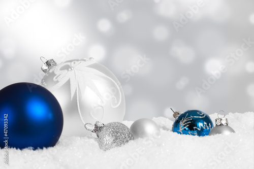 Silver and blue Christmas ornaments in snow