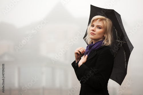 Young woman in autumn foggy morning