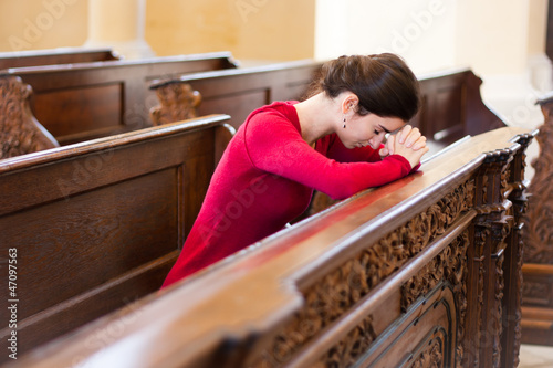 Photos Young woman praying in a church