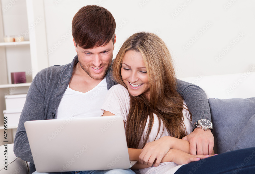 Happy young couple using computer at home Happy young couple using computer at home