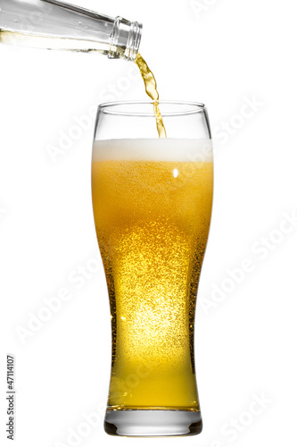 Beer is pouring into glass on white background