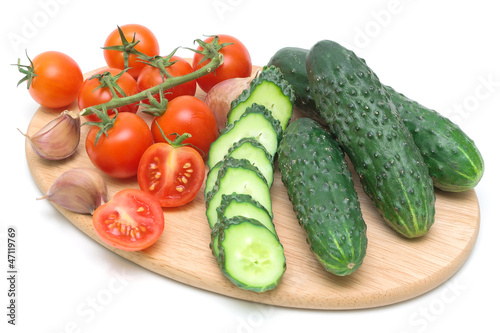tomatoes and cucumbers on the cutting board on a white backgroun
