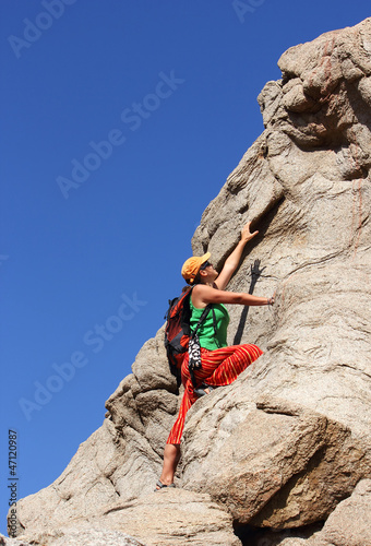 girl climbs on a rock