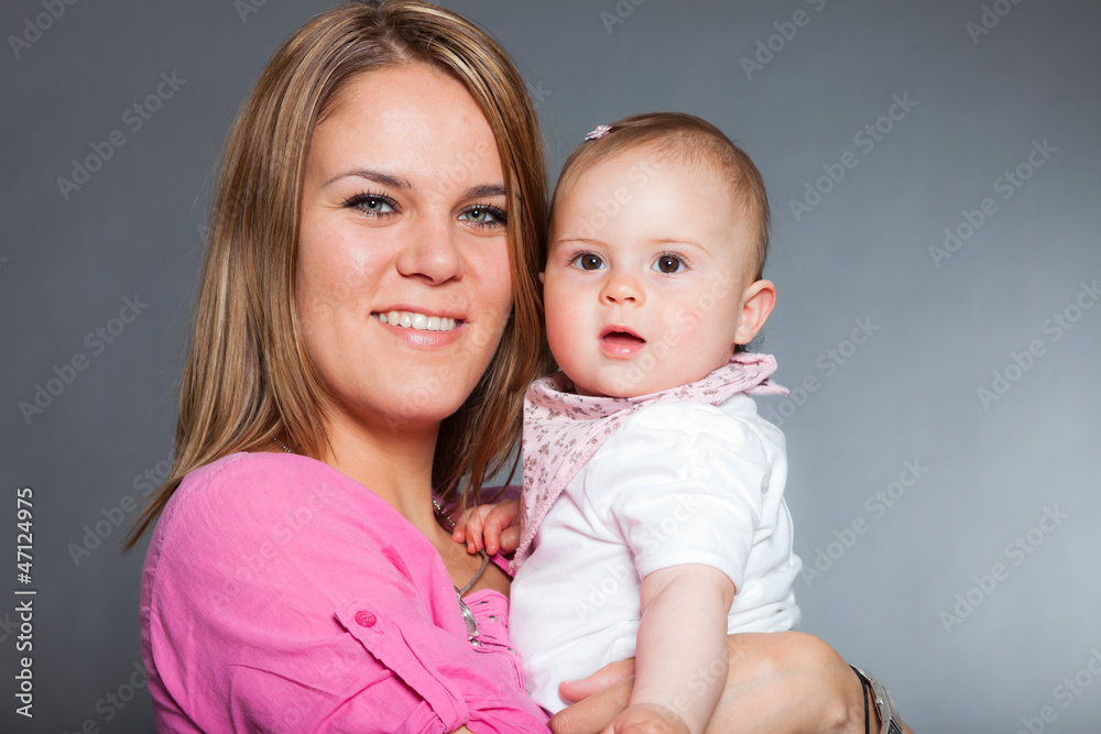 Happy young mother in love with her baby daughter. Studio shot. Happy young mother in love with her baby daughter. Studio shot.