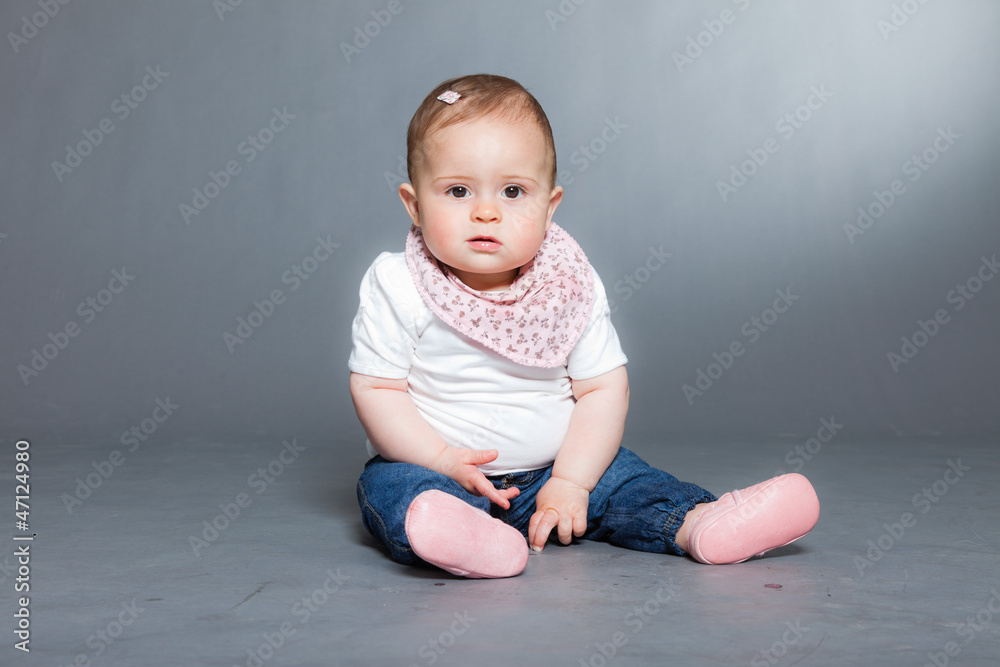 Cute baby girl against grey background. Studio shot. Cute baby girl against grey background. Studio shot.