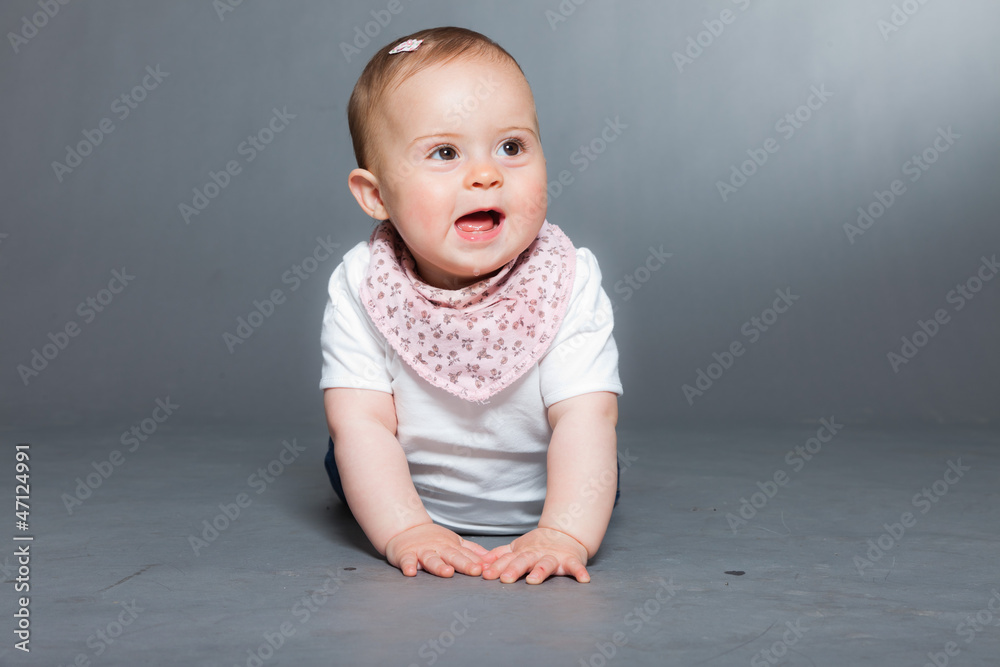 Cute baby girl against grey background. Studio shot. Cute baby girl against grey background. Studio shot.