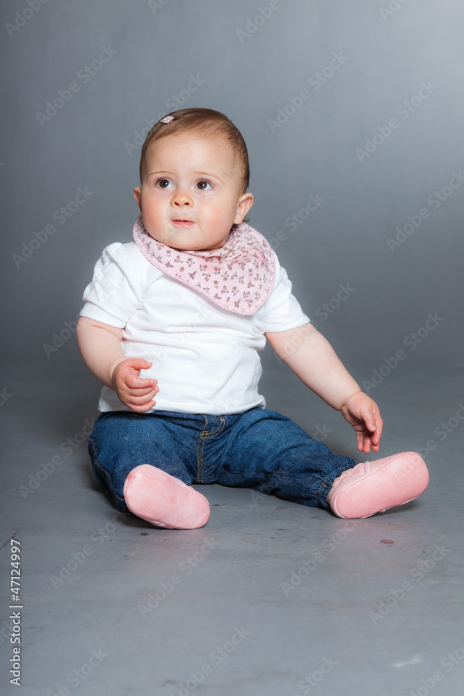 Cute baby girl against grey background. Studio shot. Cute baby girl against grey background. Studio shot.