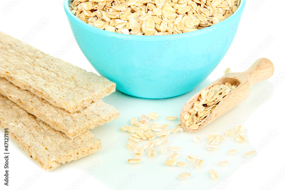 Blue bowl full of oat flakes with wooden scoop and oat biscuits Blue bowl full of oat flakes with wooden scoop and oat biscuits