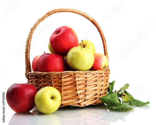 juicy apples with green leaves in basket, isolated on white