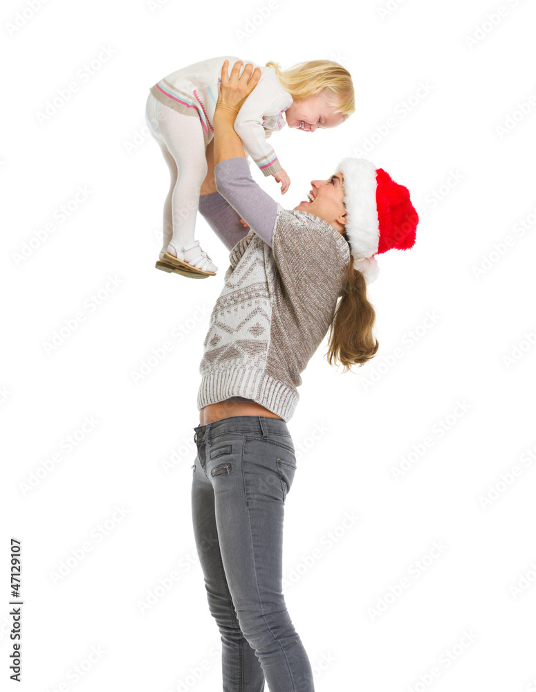 Christmas portrait of happy mother rising baby girl Christmas portrait of happy mother rising baby girl