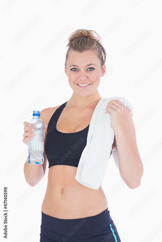 Woman standing holding a bottle and towel in sportswear Woman standing holding a bottle and towel in sportswear