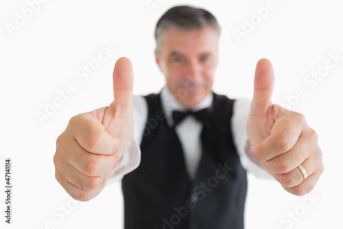 Cheerful waiter having thumbs up