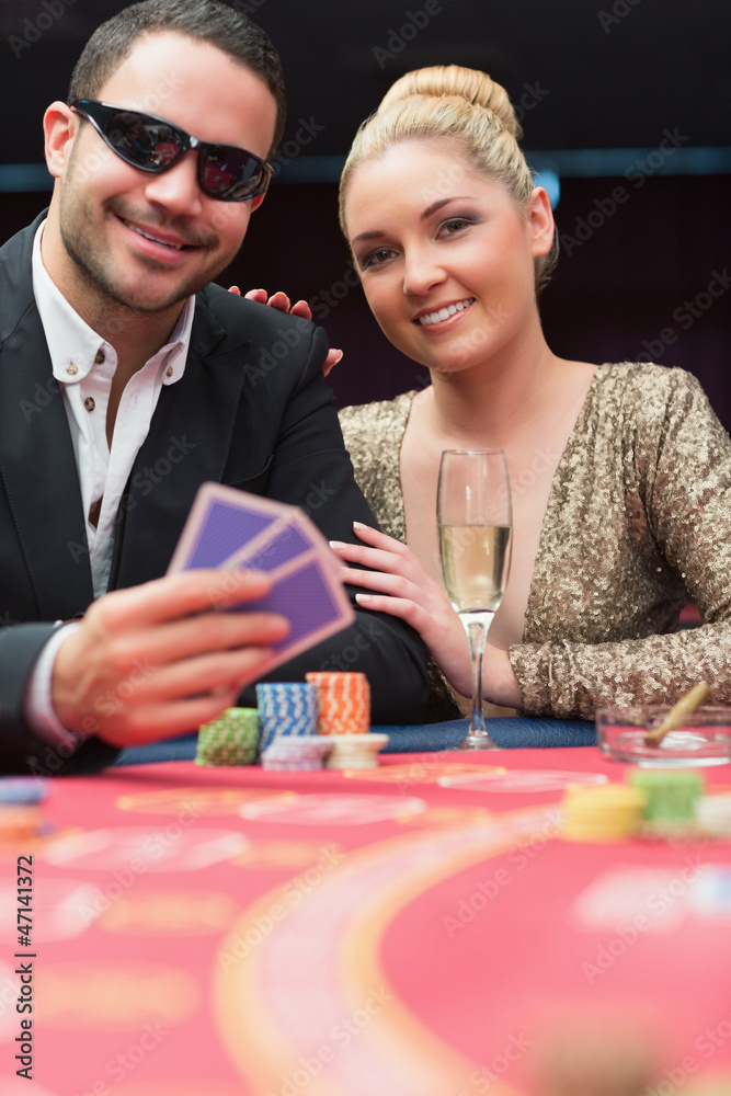 Couple sitting at the poker table smiling Couple sitting at the poker table smiling