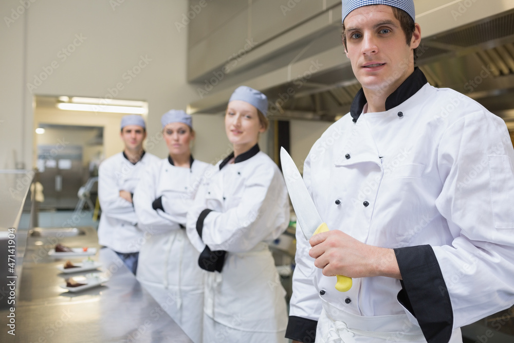 Team of Chef's with one holding a knife Team of Chef's with one holding a knife