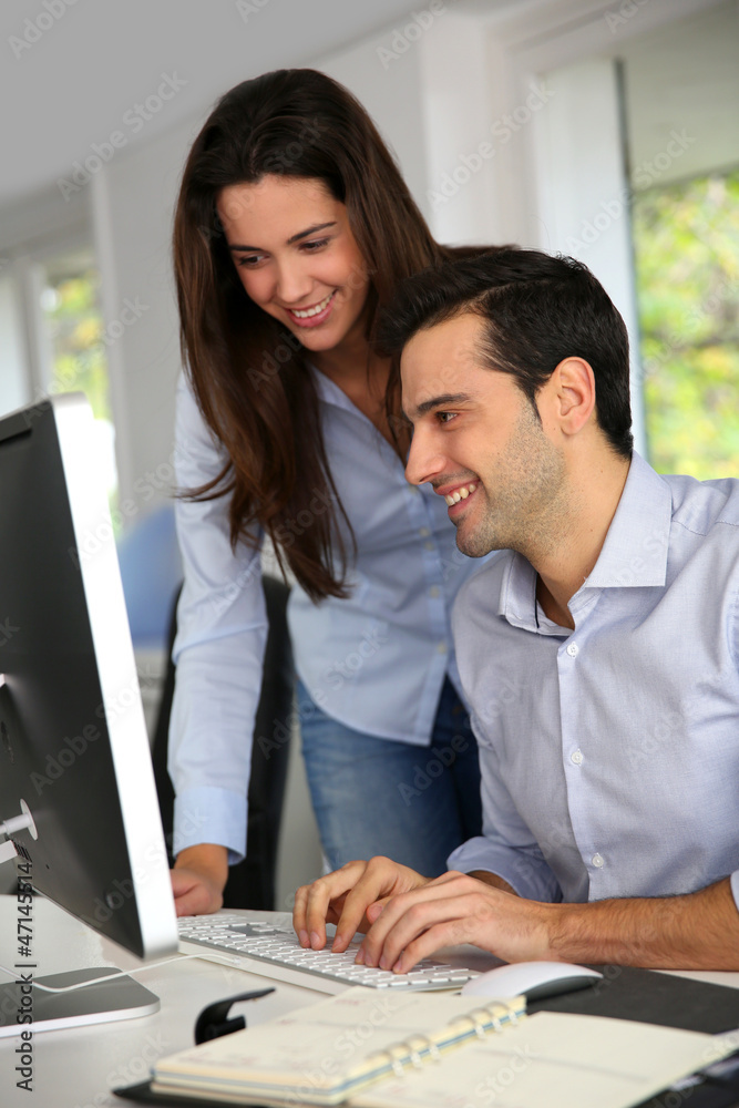 Young office workers in front of desktop computer Young office workers in front of desktop computer