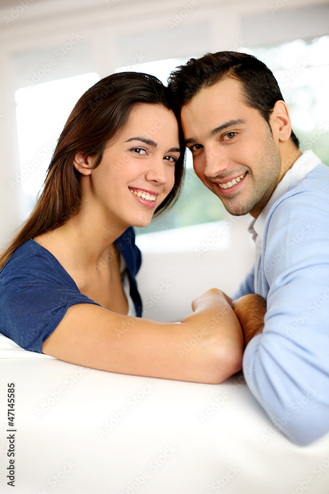 Portrait of cute young couple sitting in sofa Portrait of cute young couple sitting in sofa