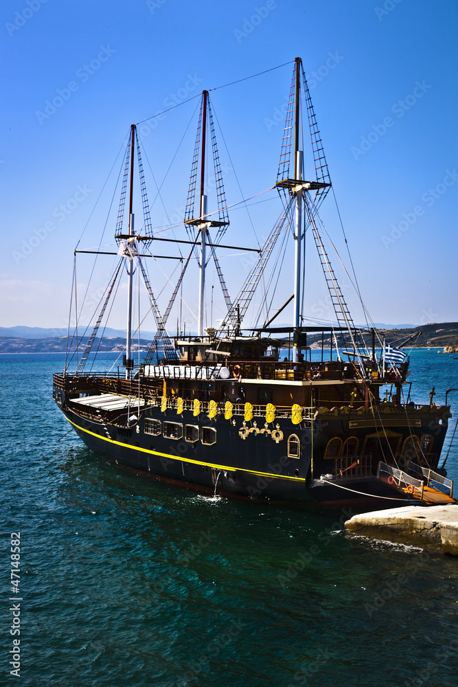 Vintage wooden ship sailing on the blue sea with blue sky