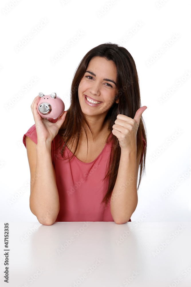 Girl holding piggy bank and showing thumb up Girl holding piggy bank and showing thumb up