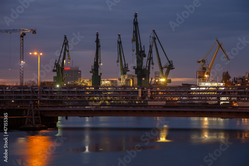 Big cranes and bridge at the shipyard at night.