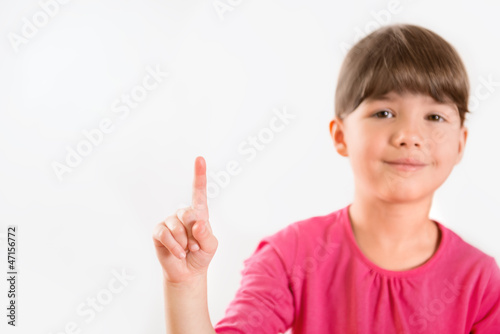 Cute little girl pointing on copy space