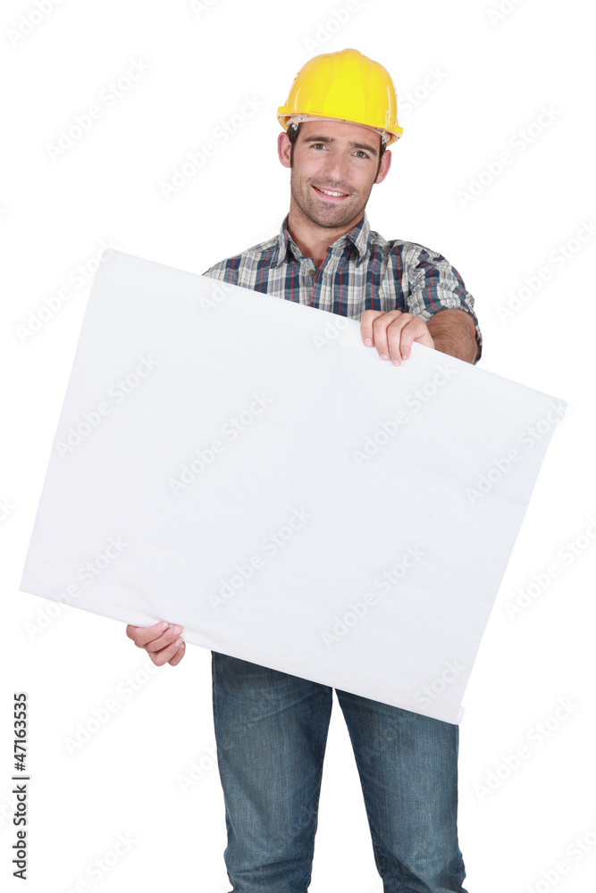 Male construction worker holding blank advertising board Male construction worker holding blank advertising board