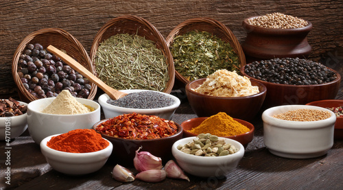 Various bowls of spices over wooden background.