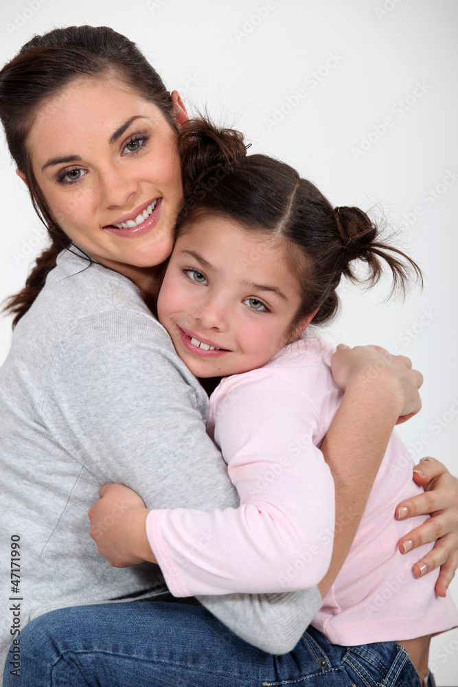 Closeup of a young woman hugging a little girl Closeup of a young woman hugging a little girl