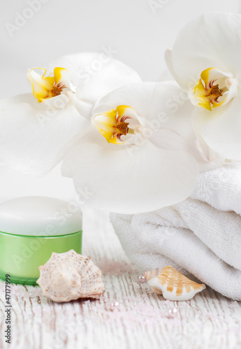 Moisturizing cream with orchids and towel