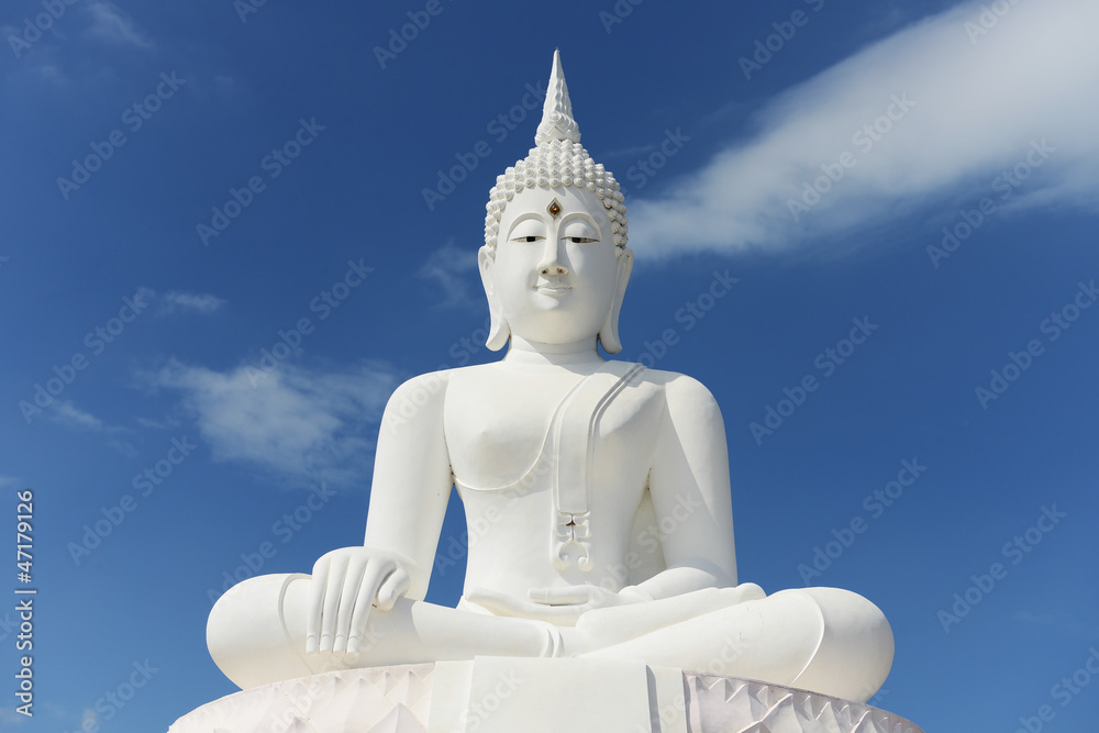 White buddha statue on blue sky background White buddha statue on blue sky background