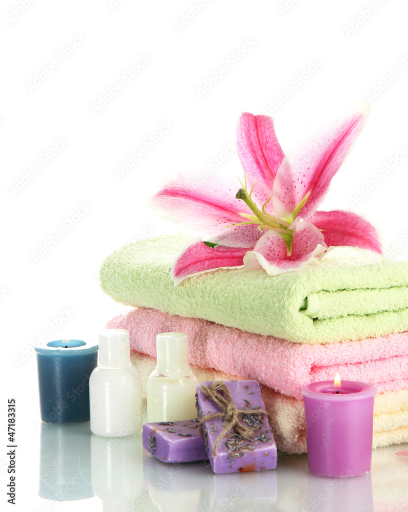 towels with lily, aroma oil, candles and soap isolated on towels with lily, aroma oil, candles and soap isolated on