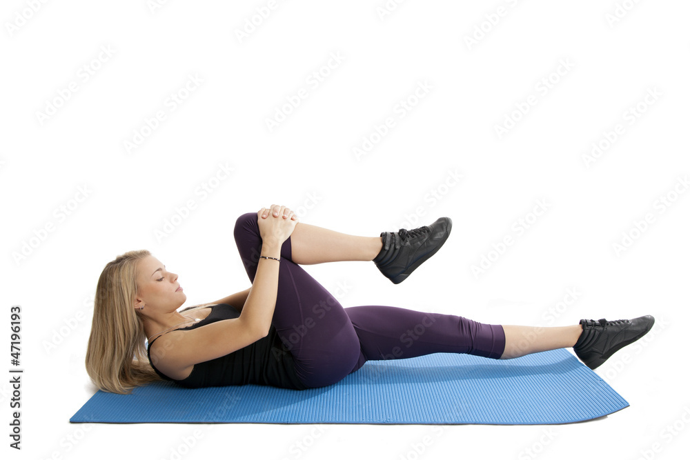 Junge Frau auf blauer Matte beim Yoga Junge Frau auf blauer Matte beim Yoga