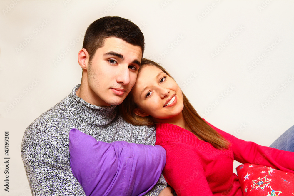 Smiling boy and girl sitting with Christmas pillows isolated on
