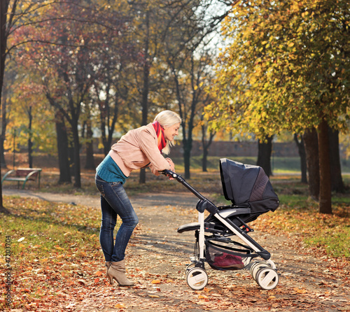 Young mother looking at her child in a stroller