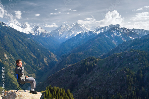 businessman at the top of the mountain is talking about new