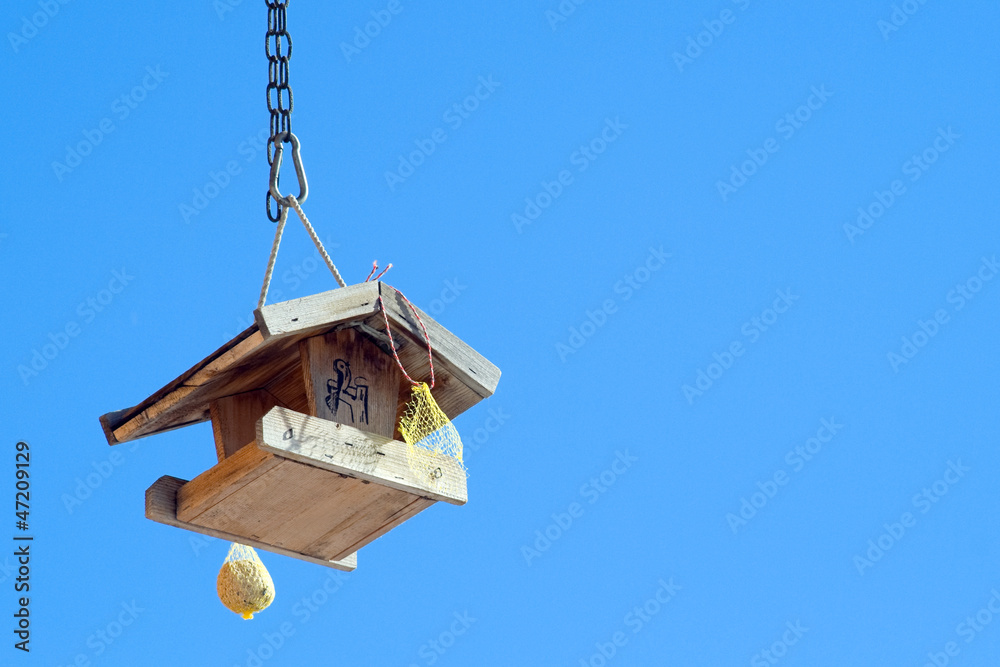 Wooden birds house (starling-house) on the blue sky Wooden birds house (starling-house) on the blue sky