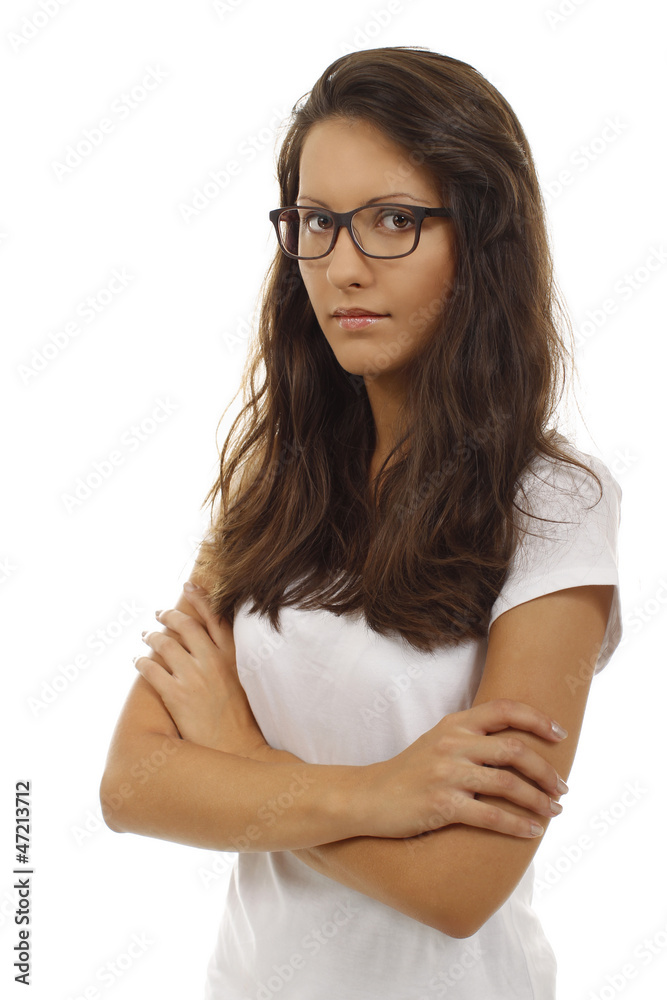 Junge Frau mit Brille und verschränkten Arme schaut ernst Junge Frau mit Brille und verschränkten Arme schaut ernst