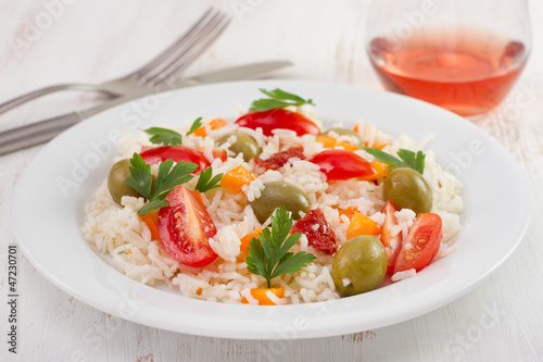 rice salad with tomato and olives on the plate