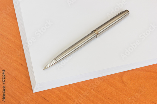 Stack of paper and pen on a table