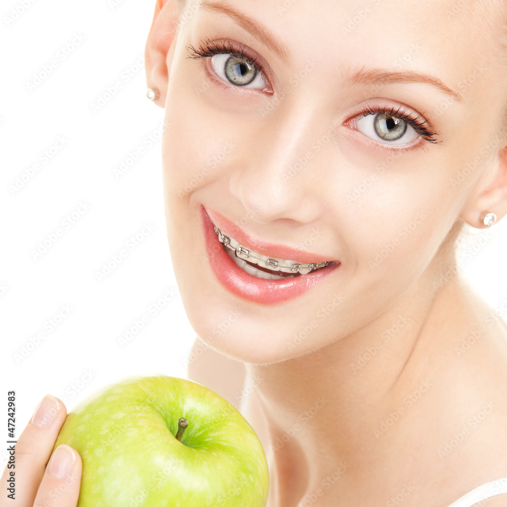 Cute girl in braces with green apple on white background Cute girl in braces with green apple on white background